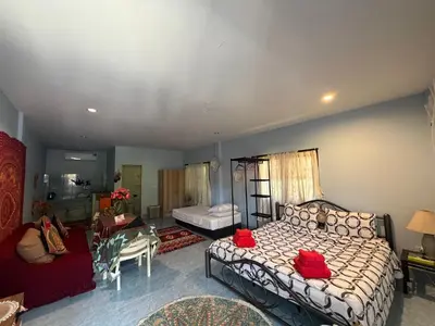 a bedroom with a bed and a living room at Bohemian apartment at Ya Nui beach in Phuket Town