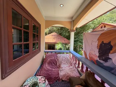 a balcony with a cat painting on the wall at Bohemian apartment at Ya Nui beach in Phuket Town