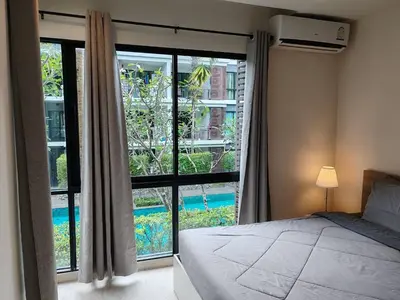a bedroom with a bed and a large window at The Title Rawai Beach front 2BD in Rawai Beach