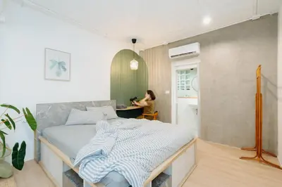 a bedroom with a bed and a woman in a kitchen at Dokdin's Family in Patong Beach