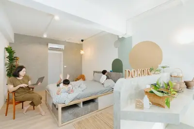 a woman sitting on a bed in a living room at Dokdin's Family in Patong Beach