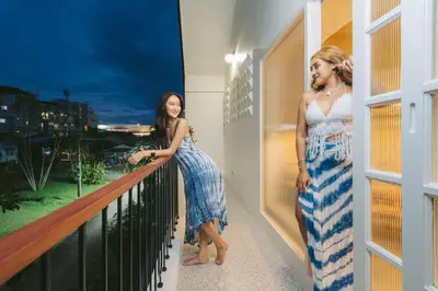 two women are standing on a balcony at Dokdin's Family in Patong Beach