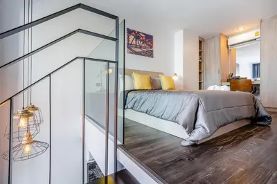 a bedroom with a bed and a glass wall at Utopia Naiharn in Nai Harn Beach