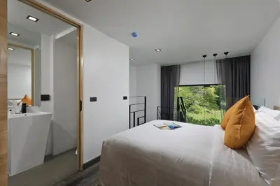 a bedroom with a large bed and a mirror at Utopia Naiharn in Nai Harn Beach