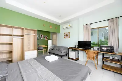 a bedroom with a bed and a desk and a couch at Sansuko Ville Panwa in Ban Bo Rae