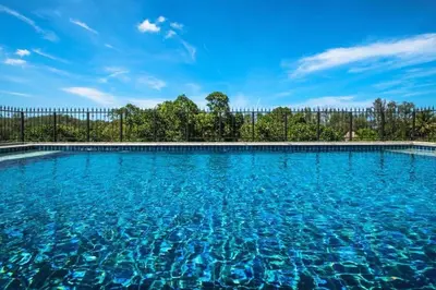 a large swimming pool with blue water at TITLE NaiYang apartment-300m from sea in Phuket Town