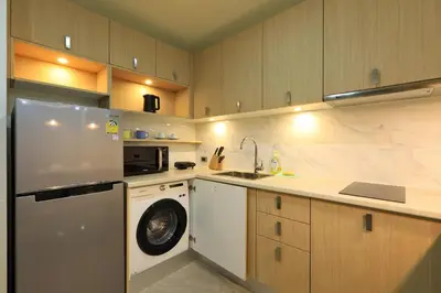 a kitchen with a washing machine and a washer at Calypso Garden by Holy Cow, 1-BR, private terrace in Rawai Beach