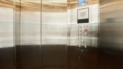 a metal elevator with a sign on it at Lime Hotel in Patong Beach
