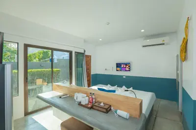 a bedroom with a large bed and a large window at Kraam Silhouette Hotel and Cafe Phuket- Chalong pier Hotel in Chalong
