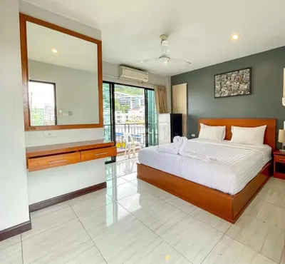 a bedroom with a large bed and a large mirror at Twenty Two House in Patong Beach