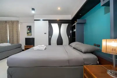 a bedroom with a large bed and a blue wall at Black Pantera Hostel in Patong Beach