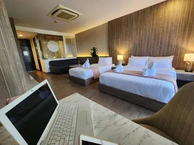 a hotel room with two beds and a laptop on a desk at Alaita Boutique Phuket in Ban Bo Rae