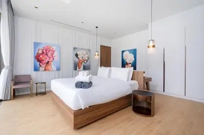 a bedroom with a white bed with a teddy bear on it at Himmapana Villas - Hills in Kamala Beach