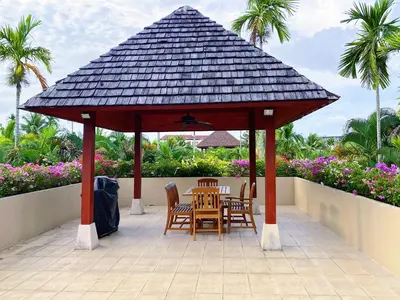 a wooden gazebo with chairs and a table at Luxe 2br Pool Villa walk to Bangtao Beach in Ban Thalat Choeng Thale