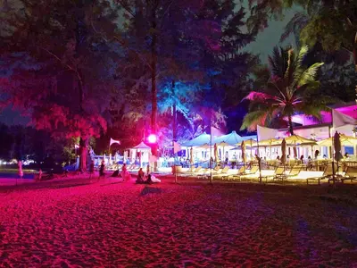 a group of people sitting on the beach at night at Luxe 2br Pool Villa walk to Bangtao Beach in Ban Thalat Choeng Thale