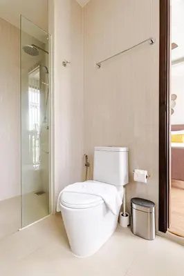 a white bathroom with a toilet and a shower at LP 65-57 Spacious holiday home close to the beach in Phuket Town