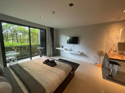 a bedroom with a large bed with a large window at Emerald Terrace Condo 3-Studio Garden Gem in Patong Beach
