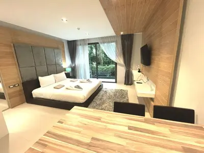 a bedroom with a bed and a desk and a table at Emerald Terrace Condo 5-Studio Garden zen in Patong Beach