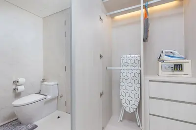a white bathroom with a toilet and a telephone at Cassia Residence Laguna Phuket Holiday Rental Apartment, Bang Tao Beach in Phuket Town