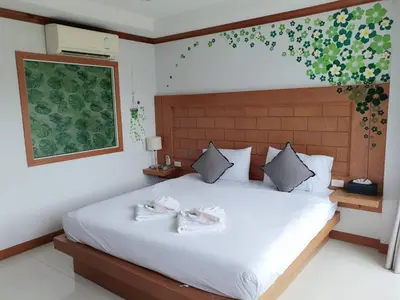 a bedroom with a bed with two towels on it at COZY Residence Patong in Patong Beach