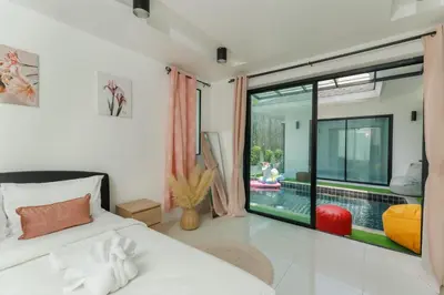a bedroom with a bed and a swimming pool at Kamala family friendly pool villa by Lofty in Kamala Beach