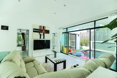 a living room with a couch and a tv at Kamala family friendly pool villa by Lofty in Kamala Beach