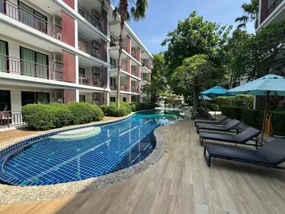 a swimming pool in front of a building at Studio Title III, Rawai Phuket in Rawai Beach
