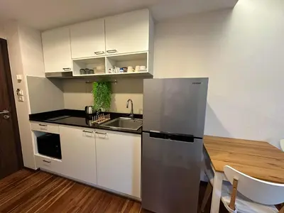 a kitchen with a stainless steel refrigerator and a table at Studio Title III, Rawai Phuket in Rawai Beach