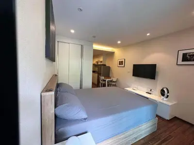 a bedroom with a blue bed and a television at Studio Title III, Rawai Phuket in Rawai Beach