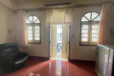 a living room with two windows and a black chair at Sonya Residence in Patong Beach