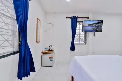 a bedroom with blue curtains and a bed and a window at GP House Krabi Aonang Beach in Ao Nang Beach