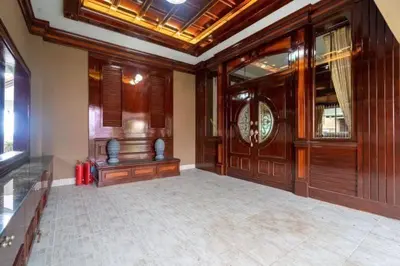 a large room with wood paneling and a clock on the wall at Cheeva Pool Villa Phuket in Phuket Town