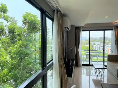 a living room with large windows and a couch at Luxury sea view apartment at Mida Grande in Surin Beach