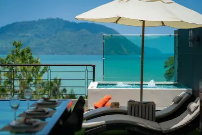 a pool with chairs and an umbrella next to a swimming pool at Villa Sabine private pool 4br seaview jacuzzi in Rawai Beach