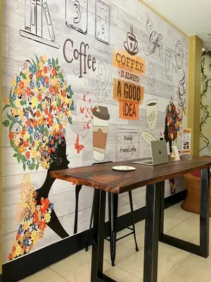 a table in front of a wall with a mural at Cozy Place in Patong Beach