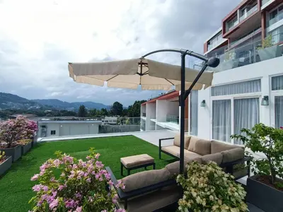a patio with a couch and an umbrella at Smart Conzept 2bdr 300m to the sea in Kata Beach