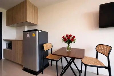 a small kitchen with a table and a refrigerator at MaiKhao Sunrise Sight Space in Ban Mai Salae