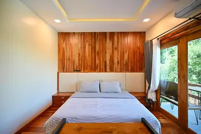 a bedroom with a bed with a wooden wall at The Moonlight Guesthouse in Patong Beach