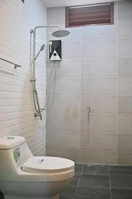 a bathroom with a toilet and a shower at The Moonlight Guesthouse in Patong Beach
