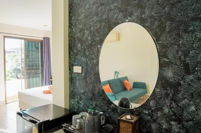 a living room with a mirror and a blue couch at Club22 Kamala Suites, Kamala Beach in Kamala Beach