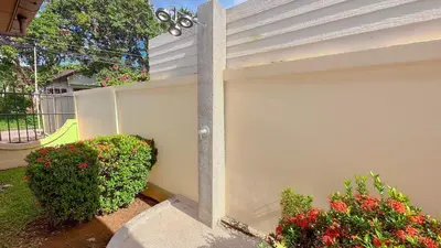 a white wall with some bushes and flowers at Garden bungalows 4br with private pool in Rawai Beach