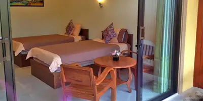 a hotel room with two beds and a table and a table sidx sidx at Baan Suan Villas Resort in Ban Suan
