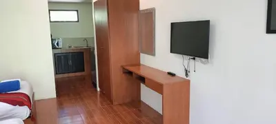 a room with a tv on the wall and a bed at Baan Suan Villas Resort in Ban Suan