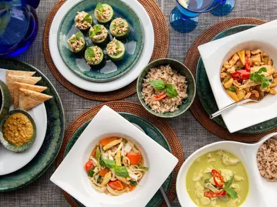 a table with plates of food and bowls of food at Infinity View by Elite Havens in Kata Beach
