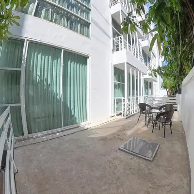 a patio with chairs and a table in front of a building at The Kris Residence in Patong Beach