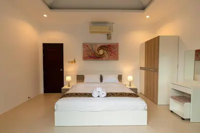 a bedroom with a bed with two white towels on it at Oriental 3br private Pool Villa in Rawai Beach