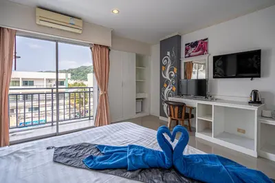 a bedroom with a bed with a view of a balcony at Santi White House Patong in Patong Beach