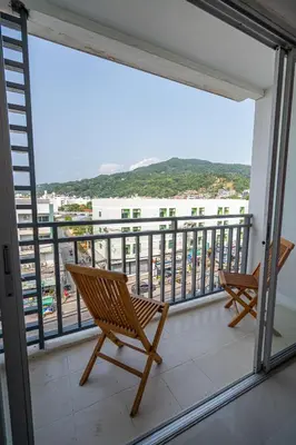 two chairs on a balcony with a view of the ocean at Santi White House Patong in Patong Beach