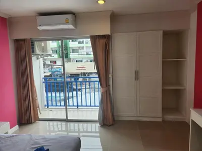 a bedroom with a window and a bed and a balcony at Santi White House Patong in Patong Beach