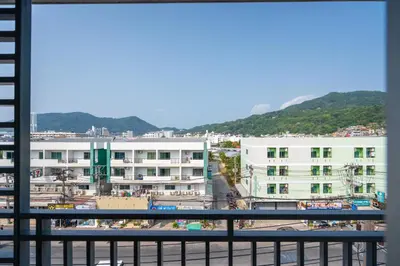 a view from a balcony of a city with buildings at Santi White House Patong in Patong Beach